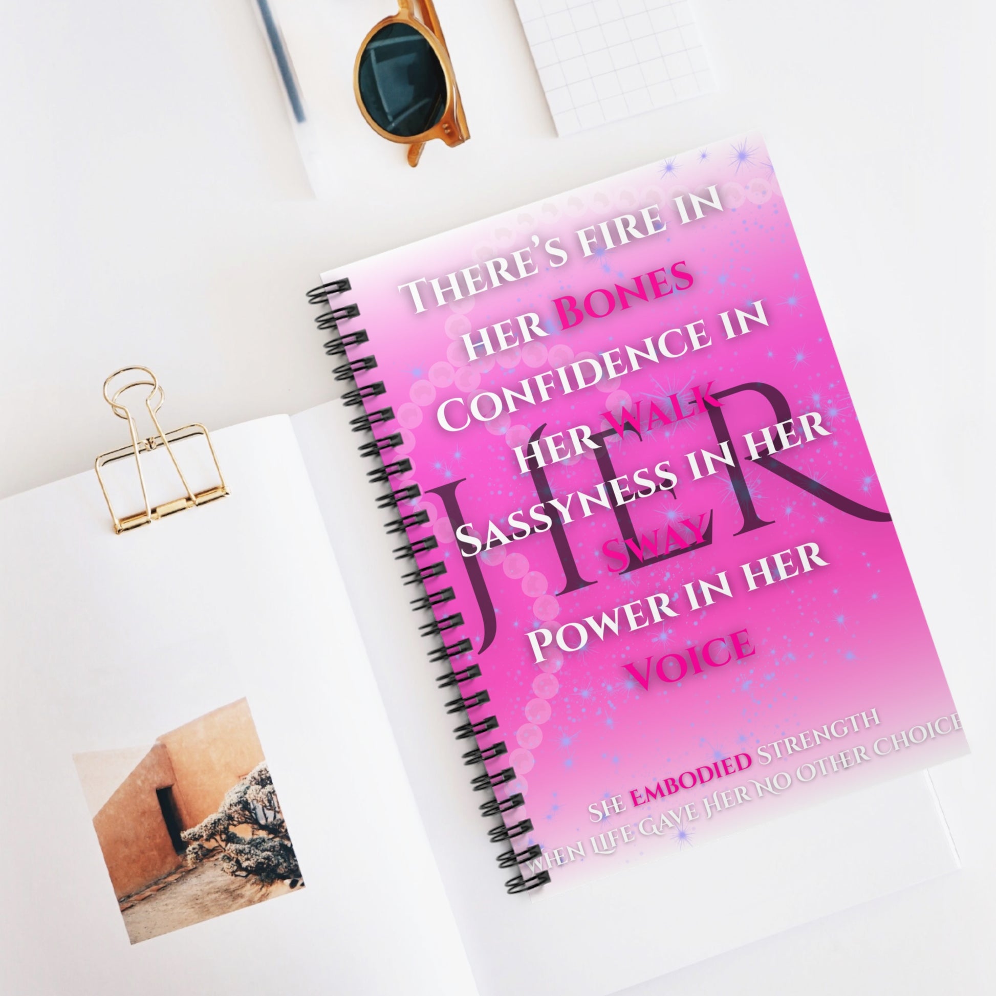 Inspirational pink spiral notebook with motivational quotes on a vibrant pink cover in a flat lay setting.